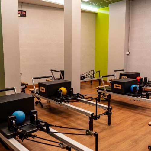 Spazio dedicato al Reformer Pilates con macchinari moderni per allenamenti personalizzati.